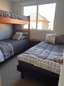 um quarto com 2 beliches e uma janela em Gran Casa confortable en Santiago em Lampa