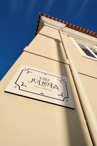 un panneau sur le côté d'un bâtiment dans l'établissement Vila Julieta Guesthouse, à Coimbra