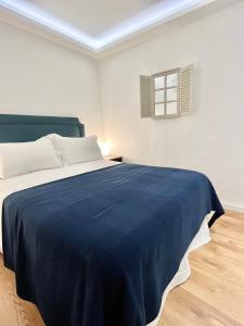 una camera da letto con un grande letto con una coperta blu di Exclusive Apartment in Historic Center a Madrid