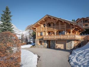 une maison en rondins dans la neige avec une allée. dans l'établissement Chalet spacieux pour 11 pers., proche pistes de ski, jardin, BBQ, équipements enfants - Le Grand-Bornand - FR-1-467-58, au Grand-Bornand