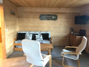 a room with a bed and two white chairs at Appartement Le Grand-Bornand, 4 pièces, 8 personnes - FR-1-467-53 in Le Grand-Bornand