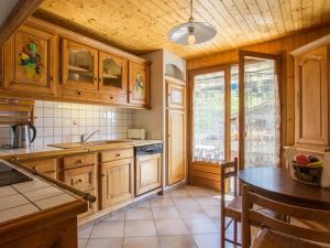 a kitchen with wooden cabinets and a table at Appartement Le Grand-Bornand, 3 pièces, 9 personnes - FR-1-467-98 in Le Grand-Bornand