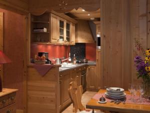 a kitchen with wooden cabinets and a wooden table and a table sidx sidx at Appartement Le Grand-Bornand, 3 pièces, 6 personnes - FR-1-467-45 in Le Grand-Bornand