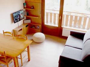 a living room with a table and a couch at Appartement Le Grand-Bornand, 2 pièces, 5 personnes - FR-1-467-86 in Le Grand-Bornand