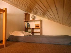 1 dormitorio con cama y estante para libros en Appartement Le Grand-Bornand, 2 pièces, 5 personnes - FR-1-467-86, en Le Grand-Bornand