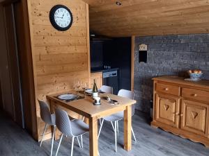 a kitchen with a table with chairs and a clock on the wall at Appartement Le Grand-Bornand, 2 pièces, 4 personnes - FR-1-467-113 in Le Grand-Bornand