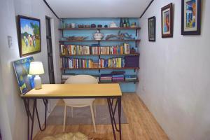 a room with a desk and a book shelf with books at Cozy 1-bedroom house in quiet residential village. in Iloilo City