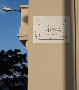 ein Schild an der Seite eines Gebäudes in der Unterkunft Vila Julieta Guesthouse in Coimbra