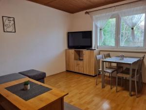 a living room with a table and a television at Rekreacny Dom in Strečno