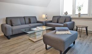 uma sala de estar com dois sofás e uma mesa em Haus Mühlentrift, FeWo 03 em Döse