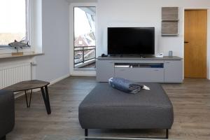 uma sala de estar com um sofá e uma televisão em Haus Mühlentrift, FeWo 03 em Döse