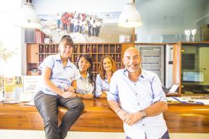 un grupo de personas sentadas en un banco de madera en Hotel Esplanade, en Cesenatico