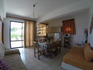 cocina y sala de estar con mesa y sillas en Milos Apartments, en Elounda