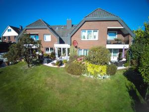 a large brick house with a green yard at Haus Mühlentrift, FeWo 09 in Döse