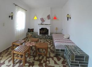 sala de estar con mesa, sillas y chimenea en Milos Apartments, en Elounda