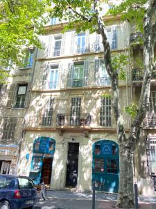 un bâtiment avec des portes et des fenêtres bleues dans une rue dans l'établissement Le Franklin Roosevelt, à Marseille