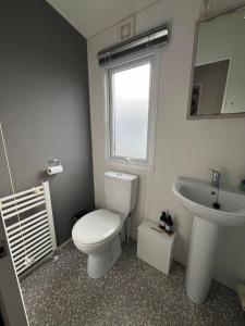 a bathroom with a white toilet and a sink at Heron, Sea View, Scratby - California Cliffs, Parkdean, sleeps 6, bed linen and towels included, pet free, onsite entertainment available in Scratby