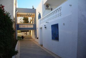 蘇塞的住宿－Villa Azaiiza，白色建筑的走廊,有蓝色的门