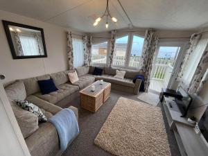 a living room with a couch and a tv at Heron, Sea View, Scratby - California Cliffs, Parkdean, sleeps 6, bed linen and towels included, pet free, onsite entertainment available in Scratby