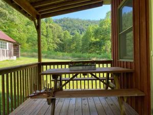 a picnic table on the porch of a cabin at Secluded Cabin on Red Haven Farm in Irvine