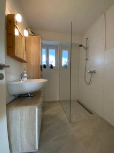 a bathroom with a sink and a glass shower at Ferienwohnung in Stegen bei Freiburg, Schwarzwald in Stegen