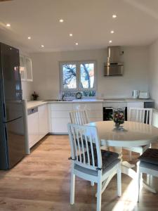 a kitchen with a white table and chairs in it at Ferienwohnung in Stegen bei Freiburg, Schwarzwald in Stegen