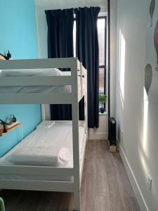 a bedroom with two bunk beds and a window at East Harlem Hostel in New York