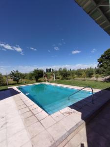 een zwembad in een tuin met een blauwe lucht bij Finca Las Acacias in Maipú