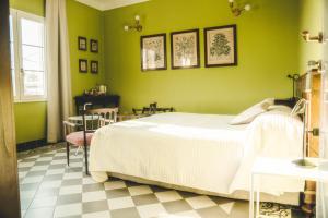 1 dormitorio con cama blanca y paredes verdes en Azienda agricola La Macina, en Bregnano