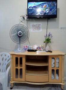 馬六甲的住宿－Thian Siong Inn，一张带风扇的桌子和一台墙上的电视