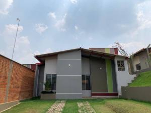 a small house with a brick wall and grass at Acogedora casa en Cobija in Tres Puentres