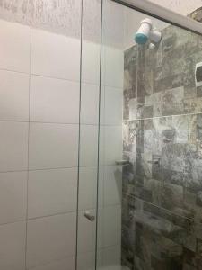 y baño con ducha y puerta de cristal. en Acogedora casa en Cobija en Tres Puentres