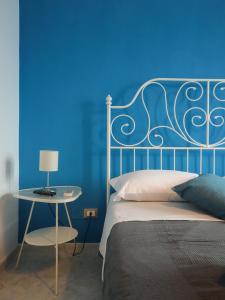 1 dormitorio con pared azul, cama y mesa en La Darsena Fiumicino, en Fiumicino