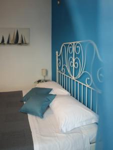 Un dormitorio con una cama azul y blanca con almohadas en La Darsena Fiumicino, en Fiumicino