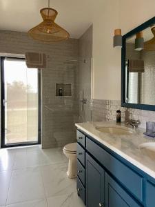 a bathroom with a sink and a toilet and a mirror at Quinta Alto da Fraga in Vila Nova de Foz Coa