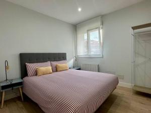 a bedroom with a large bed and a window at Apartamentos 2K - Apartamento en el centro de Castro Urdiales reformado in Castro-Urdiales