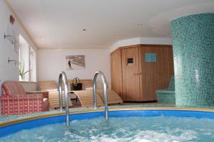 uma banheira de hidromassagem num quarto com uma sala de estar em Pension Widmann em Stulles