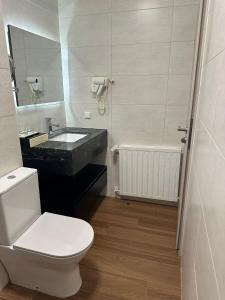 a bathroom with a toilet and a sink and a tub at hotel whiteswan in Ehnen