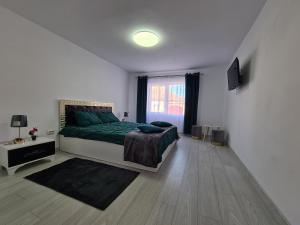 biała sypialnia z zielonym łóżkiem i oknem w obiekcie Margareta's House w mieście Veştem