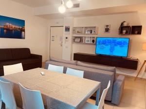 a living room with a table and a couch and a television at Berga Exclusive Suite 5 in Bari