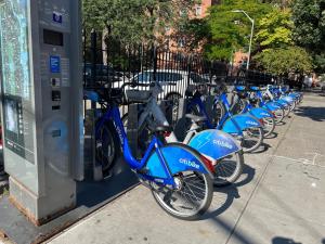 a row of blue bikes parked next to a parking meter at East Harlem Hostel in New York