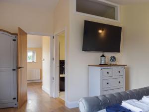 a living room with a couch and a tv on the wall at The Lookout - Uk35022 in Hope under Dinmore