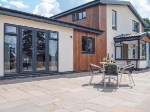 a patio with a table and chairs in front of a house at The Lookout - Uk35022 in Hope under Dinmore