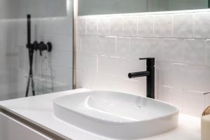 y baño blanco con lavabo y ducha. en Almada 551 - 4 1 Penthouse View by LovelyStay en Oporto