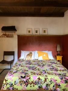 Casa Pintassilgo mini في سانتا كروز كابراليا: غرفة نوم مع سرير كبير مع بطانية ملونة