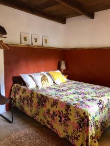 a bedroom with a bed with a colorful bedspread at Casa Pintassilgo mini in Santa Cruz Cabrália