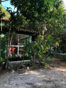 zielony dom z drzewem przed nim w obiekcie Casa Pintassilgo mini w mieście Santa Cruz Cabrália
