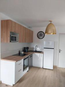 - une cuisine avec des appareils blancs et des armoires en bois dans l'établissement T3 avec jacuzzi privé exterieur, à Ceyreste