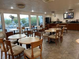 a restaurant with tables and chairs in a room at Wenatchee Inn in Wenatchee