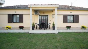 a house with a table and chairs on a patio at Garden Paradise in Megalochori Trikala in Tríkala